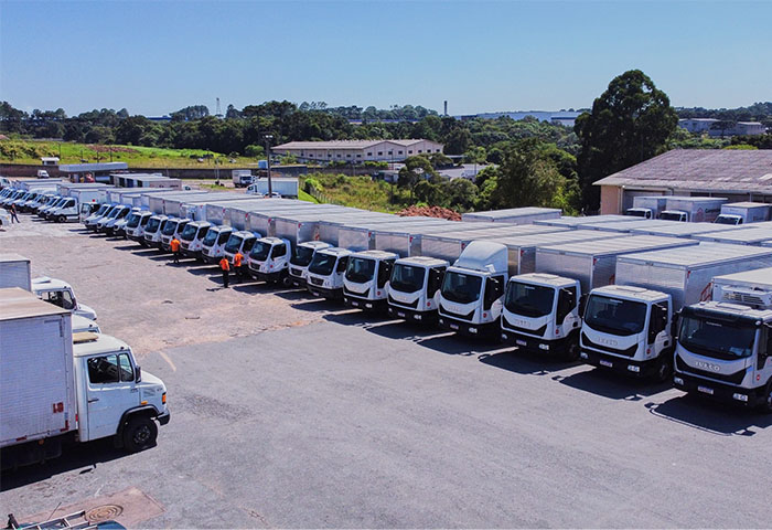 Frota de caminhões da Campodoro estacionada em pátio logístico, pronta para operações de transporte em grande escala.